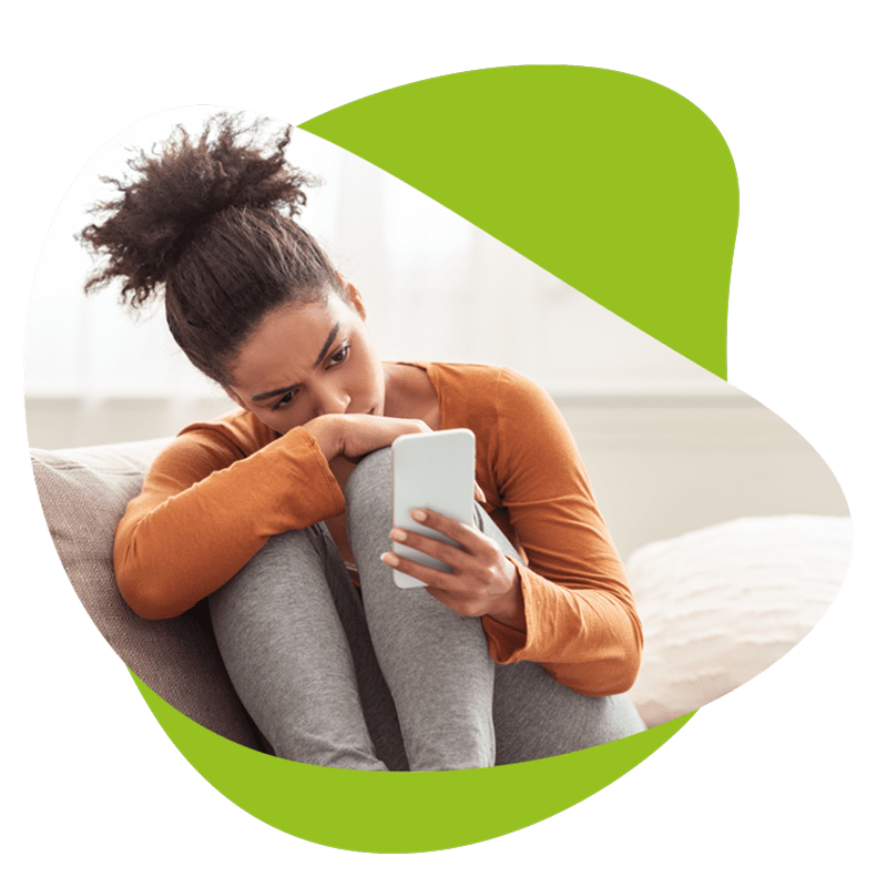 Eine junge Frau, die auf der Couch sitzt und eine Notfallbenachrichtigung erhalten hat